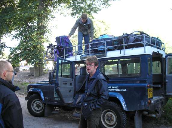 Photo of Duncan stacking rucksacks on the roof of the Landrover.